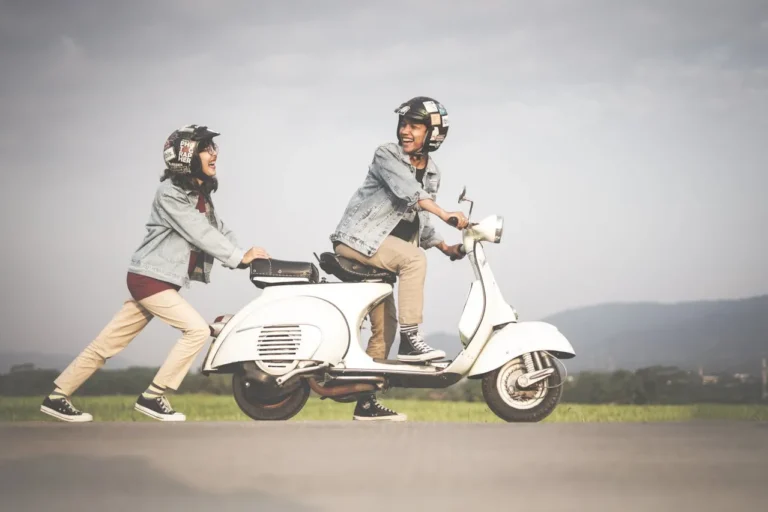 2 people enjoying their time while riding vespa